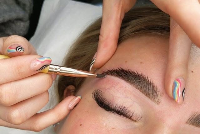 Tweezers shaping a client’s brow