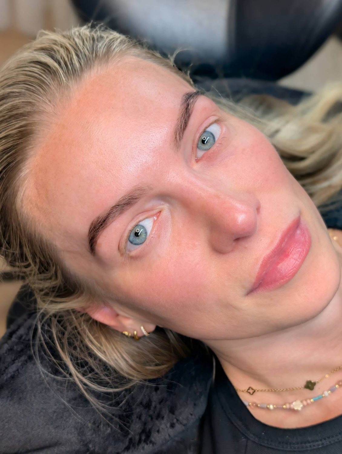 A client looking up at the camera with finished brows