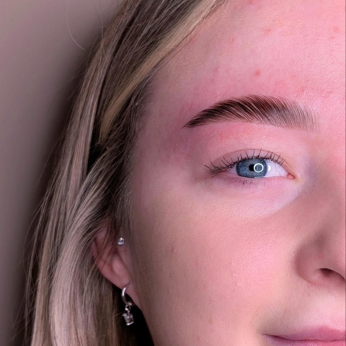 Close-up of one finished brow on a client with blue eyes